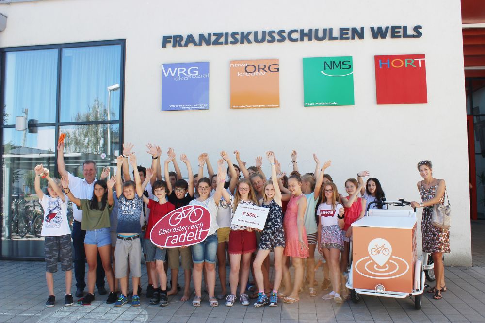 Gewinnerklasse der Fraziskusschule Wels hinter dem OÖ radelt Logo