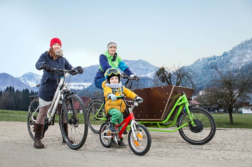 Eltern mit Kind fahren im Winter mit dem Fahrrad.